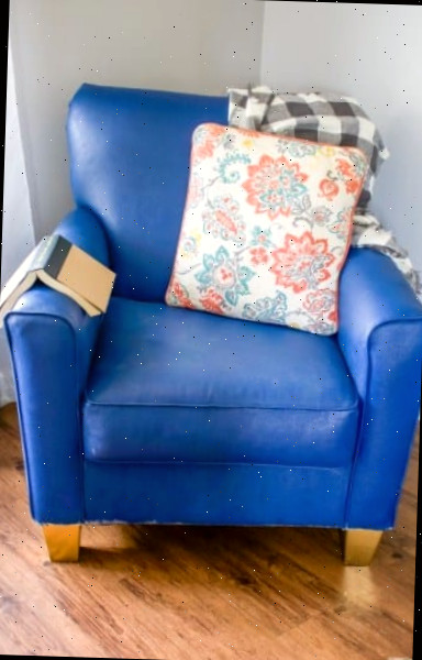 Uma sala de estar com um assento azul em uma cadeira