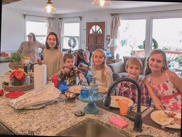 Um grupo de pessoas sentadas à mesa posando para a câmera