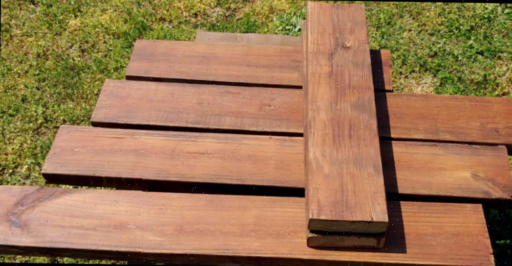 Pranchas de madeira tratadas. Madeira tratada sob pressão, manchada com verniz externo para fazer uma cama de jardim elevada simples.