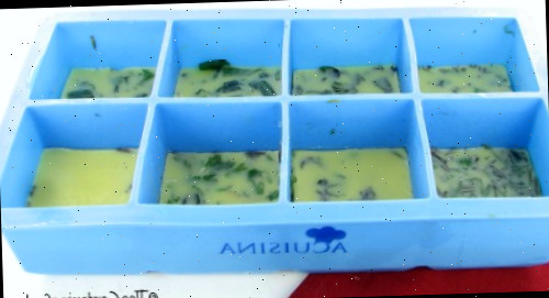 Ervas frescas congeladas em manteiga em formas de gelo de silicone.