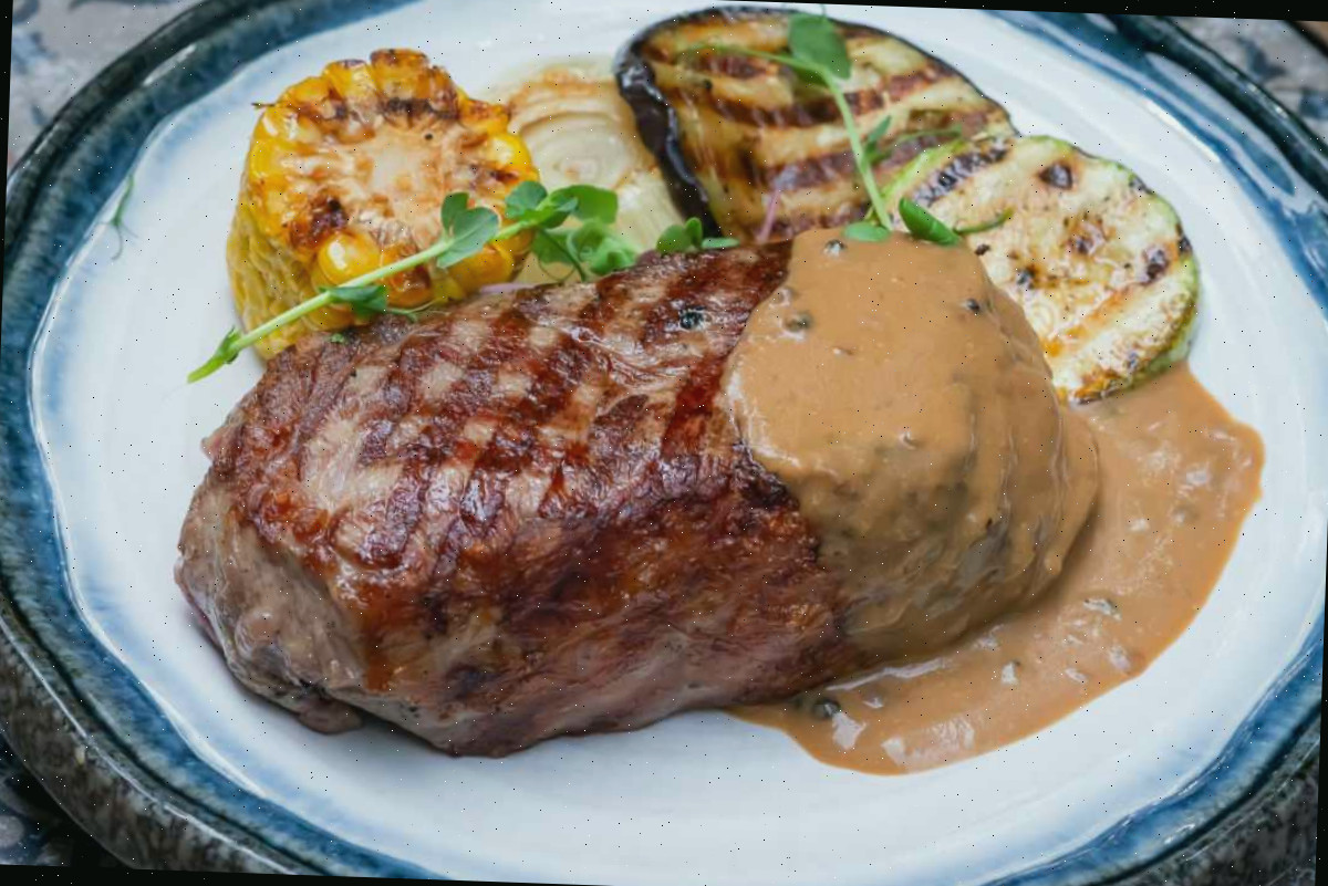 Marcas de grelha nos alimentos Carne e legumes em um prato com marcas de grelha e molho.