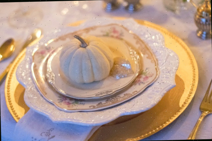 white pumpkins on individual table settings configuração de mesa de feriado com pequena abóbora