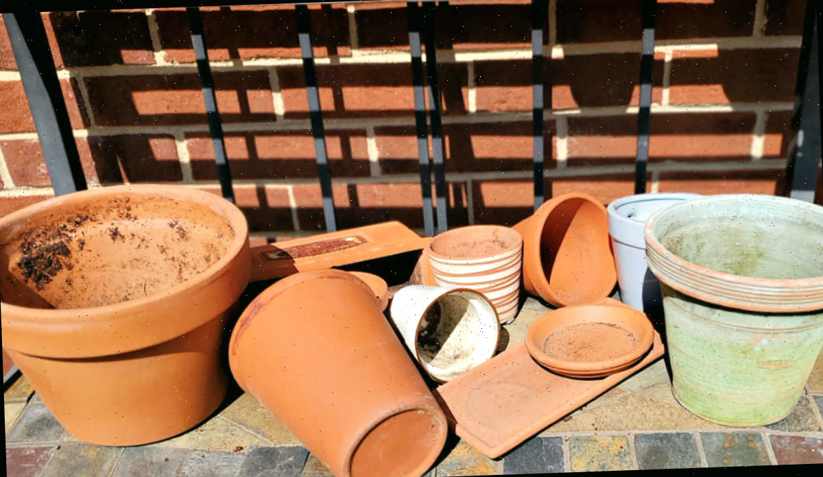 Um conjunto de vasos e pratinhos de barro sujos e danificados que precisam ser limpos e desinfetados no início da primavera.