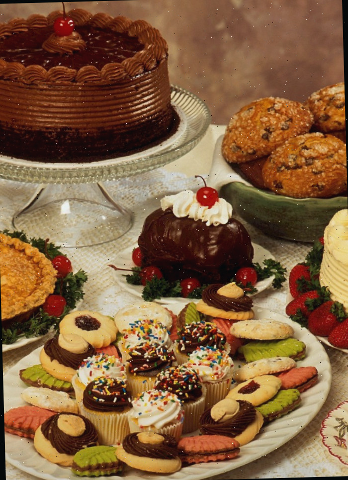 Bolo, muffins, doces e outras iguarias natalinas em pratos.