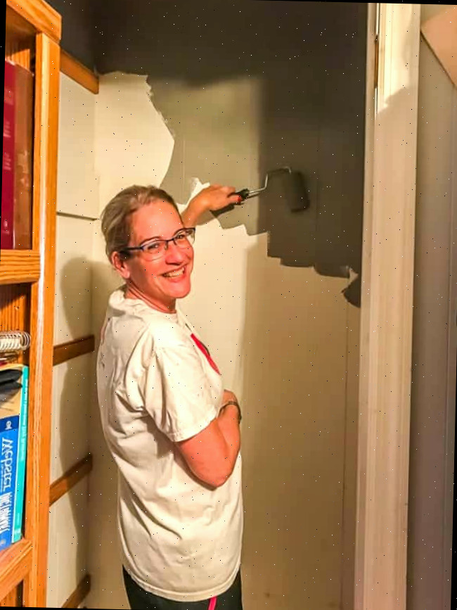 pintando as paredes de cinza no pequeno armário de roupas de cama