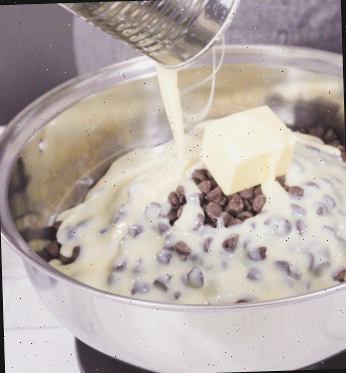 Fazendo fudge. Gotas de chocolate, manteiga e leite condensado para fazer fudge.
