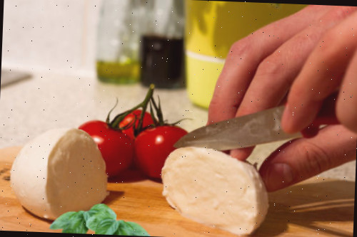 cortando queijo tomate, manjericão e mussarela