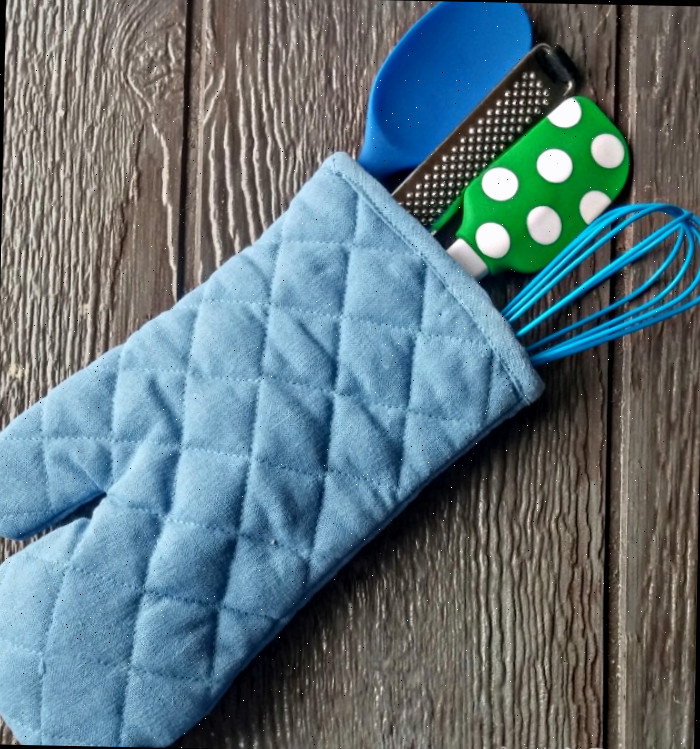 Suporte azul cheio de ferramentas de cozinha de silicone.