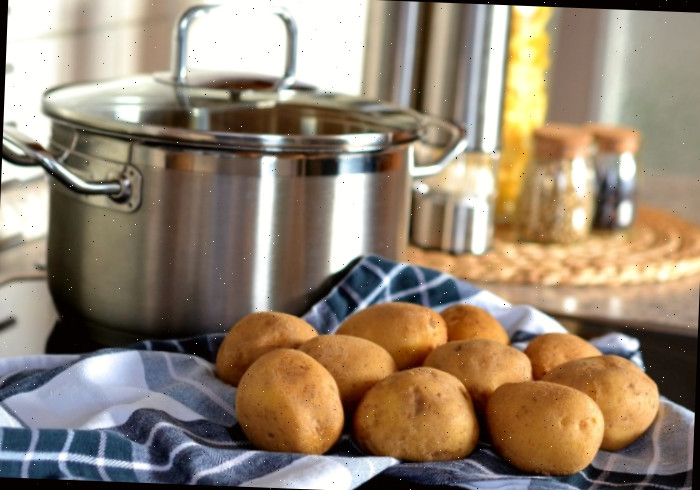 Batatas e uma panela com toalha azul e especiarias.