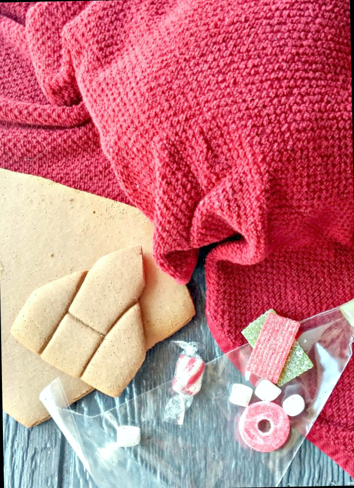 Pedaços de gengibre, guloseimas, saco de confeitar e um pano de prato limpo cobrindo a tigela de glacê real.