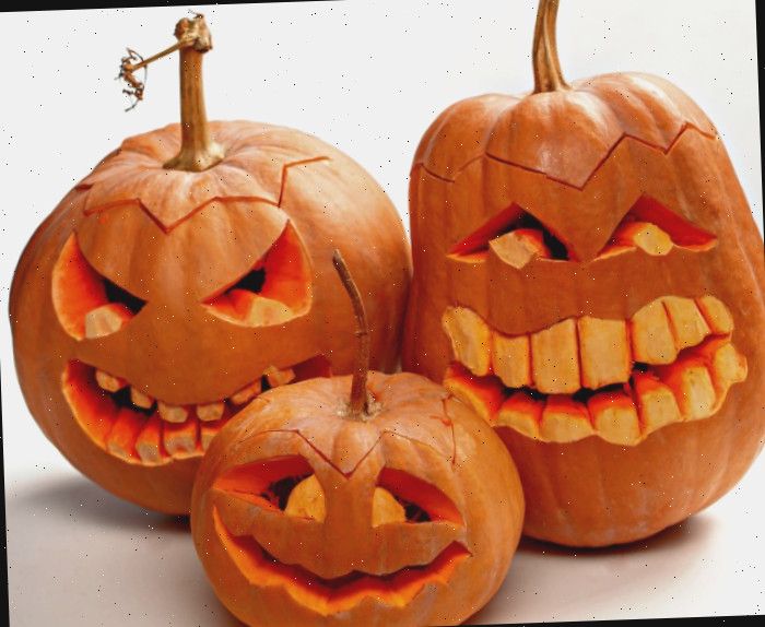 Trio de abóboras sorridentes esculpidas com dentes grandes.