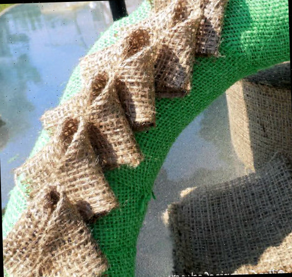 Pétalas de juta marrom no meio de uma forma de guirlanda de juta verde.