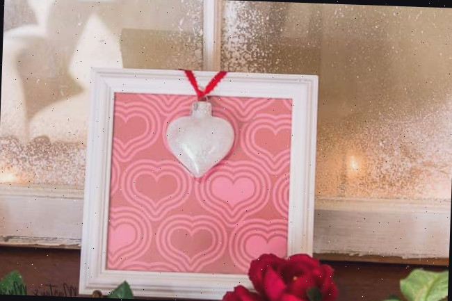 Um vaso de flores está em frente a uma janela