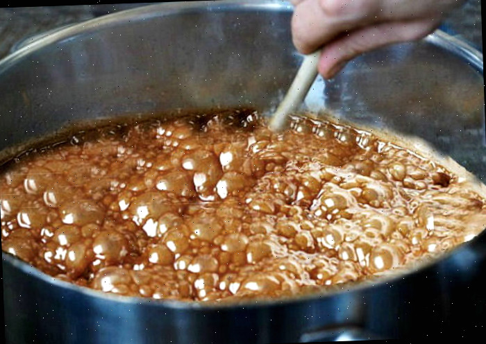 mexendo fudge Mão com colher de madeira mexendo fudge.