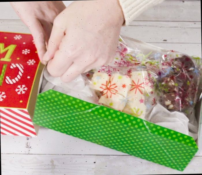 Embrulhando fudge para presentes. Embrulhando fudge em plástico em uma caixa de presente de Natal.