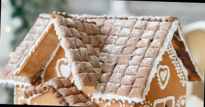 Telhado de palha com beirais em uma casa de gengibre decorada com glacê real.