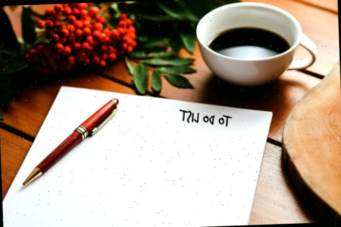Copo de café e flores com uma caneta e papel com as palavras lista de afazeres.