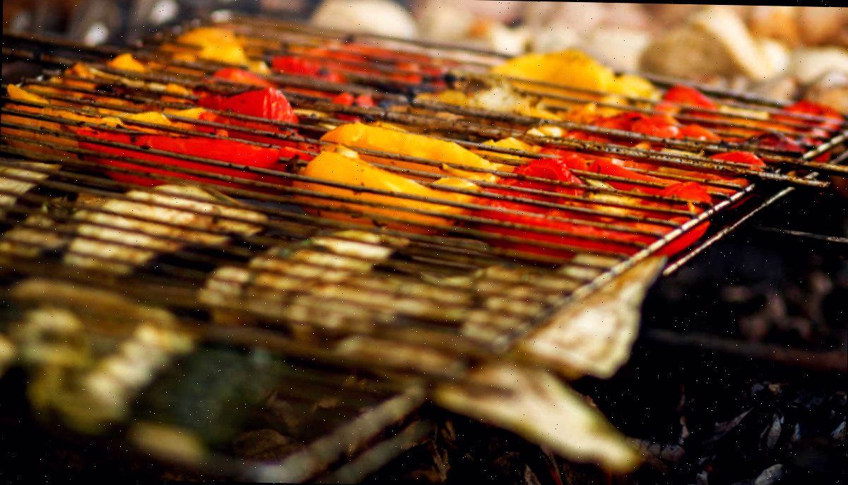 Cestas para grelhar alimentos delicados Legumes em uma cesta para grelhar sobre carvão.