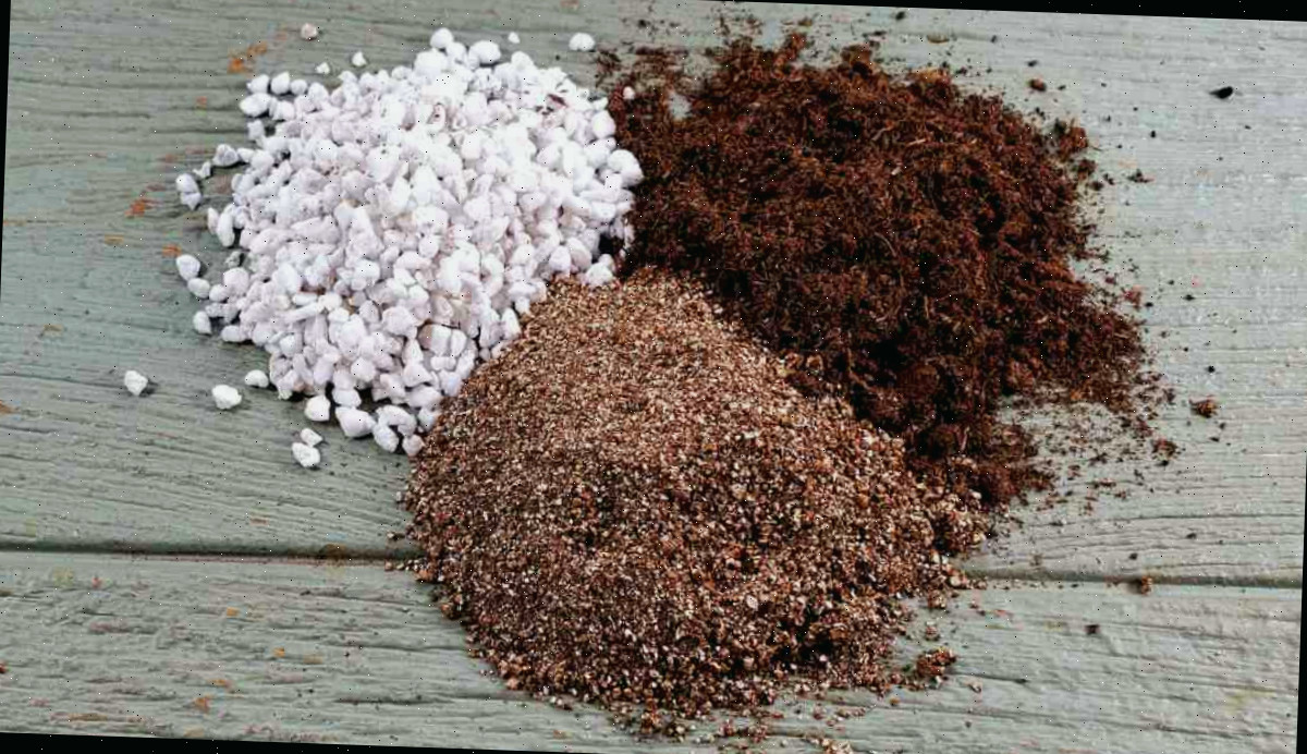 Vermiculita, musgo de turfa e perlita em montes sobre uma tábua de madeira para misturar no início de sementes em ambiente interno.