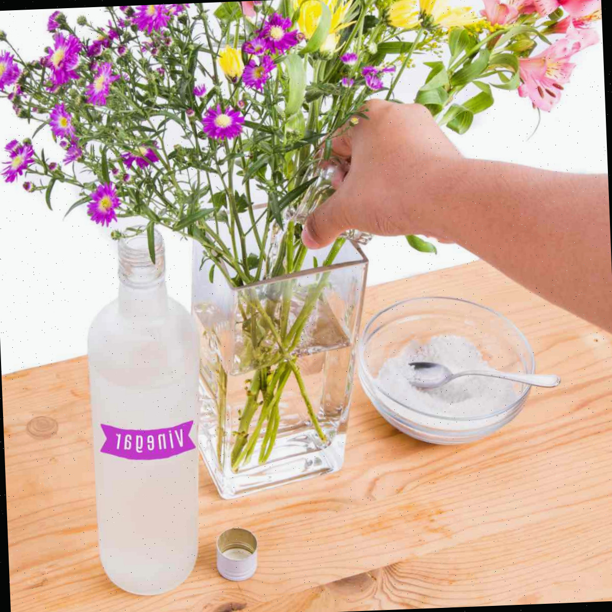Adicionando vinagre e açúcar às flores em um vaso.