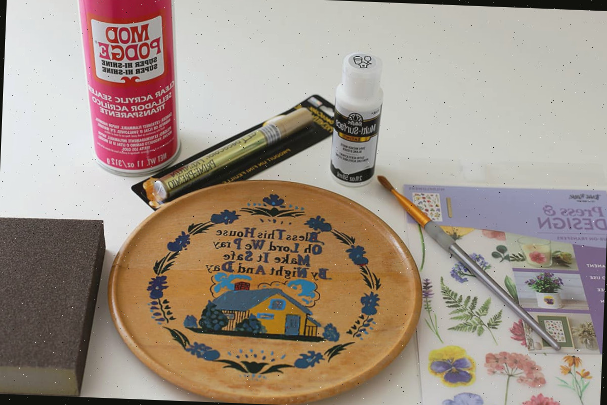 Materiais para reaproveitar uma placa de madeira de cozinha kitsch dos anos 1960. Inclui tinta, selante acrílico e transfers.