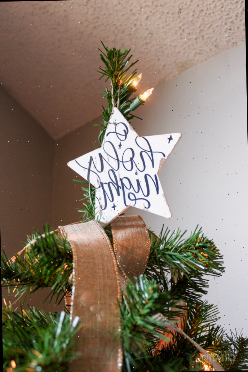 ornamento em forma de estrela 'ó santa noite' no topo da árvore de Natal