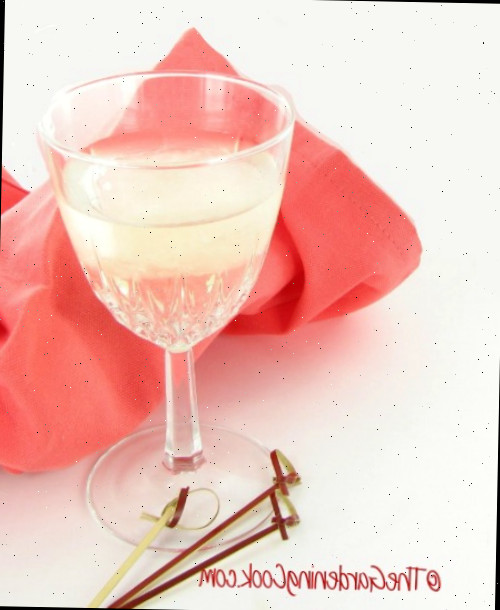 Frozen wine cubes Cubos de vinho congelados em um copo de vinho com canudinhos de coquetel e um guardanapo pêssego.